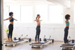 © Wavebreak Media - Diverse women practice Pilates on reformers in a bright studio