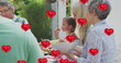 Image of heart balloons over happy caucasian family eating together in garden