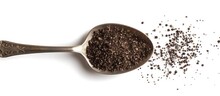 A Teaspoon Is Filled With A Scoop Of Black Seed Against A White Background. The Black Seeds Are Neatly Contained Within The Spoon.