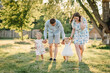 © Serhii - Mom, dad, and kids walking in park at sunset. Mother, father hold hands happy children daughter. Running in green grass in nature on summer day. Concept of family spending time together on a picnic.