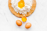 Fototapeta Lawenda - Making dough concept. Pile of flour and eggs on white background top view space for text