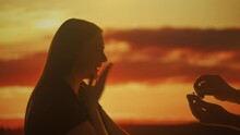 Silhouette Of A Woman Accepting An Engagement Proposal At Sunset