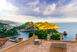 Fototapeta  - panoramic view from a hotel balcony with terrace to a beautiful sea gulf with sceniv isle and mountains with cloudy sky on background