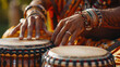 Close-up of a musician's hands playing a traditional drum with intricate details, adorned with colorful bracelets and a ring, blending cultural music with vibrant attire indicative of rich heritage.