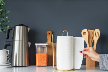 Woman tearing paper towels in kitchen, closeup