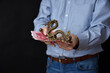 Businessman holding banknotes in his hand. Chinese RMB cash and symbolic dragon.