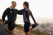 © Katie/peopleimages.com - Road, stretching and woman with man for fitness, workout coach and help for healthy body. Exercise, wellness and girl runner with personal trainer in muscle warm up for outdoor training in morning.