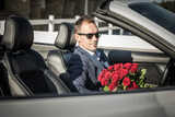 Fototapeta Zachód słońca - Elegant Man with Red Roses Awaiting His Date