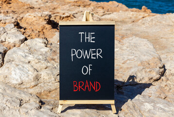 The power of brand symbol. Concept words The power of brand on beautiful black chalk blackboard. Beautiful stone blue sea sky background. Business the power of brand concept. Copy space.