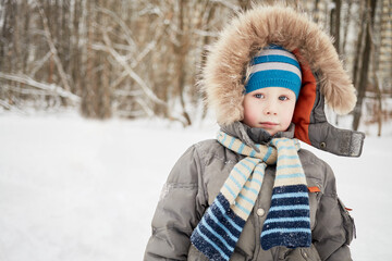 Half-length portrait of boy dressed in winter jacket with fur trimmed hood