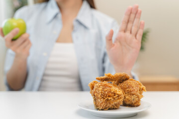 Canvas Print - Diet food loss weight concept, Hand of woman pushing fast food away and avoid to eat fried chicken to control cholesterol and sugar.