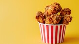 Fototapeta Panele - Fried Chicken wings and legs. Bucket full of crispy kentucky fried chicken on yellow background
