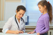 © Pavel Losevsky - Health worker writing prescription for young girl in exam room, focus on woman