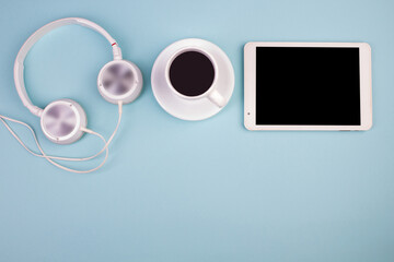 Tablet, calculator, phone, pen and a cup of coffee, lot of things on a blue background. Top view with copy space.