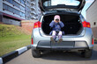 © Pavel Losevsky - Little girl sitting in open trunk of car and looking through binoculars
