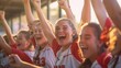 Closeup photo of a softball players celebrating a victory in the evening with fans in the background