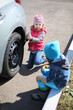 © Pavel Losevsky - Little girl with boy tie rear wheel of car with socket wrench