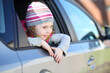 © Pavel Losevsky - Happy little girl in striped hat looking out car window