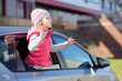 © Pavel Losevsky - Happy little girl waving her hands out of the car window