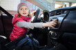 © Pavel Losevsky - Little girl in pink waistcoat and striped hat sitting at wheel of car