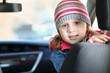 © Pavel Losevsky - Portrait of little girl in pink waistcoat and striped hat sitting in car