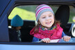 © Pavel Losevsky - Portrait of happy little girl in striped hat looking out car window
