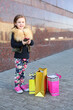 © Pavel Losevsky - Happy little girl with pink phone and shopping bags