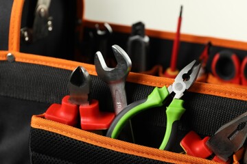 Bag with different pliers, wrench and other tools for repair, closeup