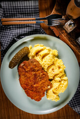 Wall Mural - Breaded pork neck cutlet served with potatoes and pickled cucumber.