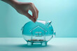 Hand putting a coin in piggy bank in a shape of a house. Saving money for buying a home, financial literacy. Budgeting, savings and investing. Finance, property purchase, mortgage and loan concept