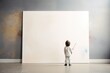 A child in white attire stands before a large, blank canvas, brush in hand, ready to make their mark