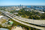 Fototapeta Mapy - Aerial view of Jacksonville city with high office buildings and american freeway intersection with fast moving cars and trucks. USA transportation infrastructure concept