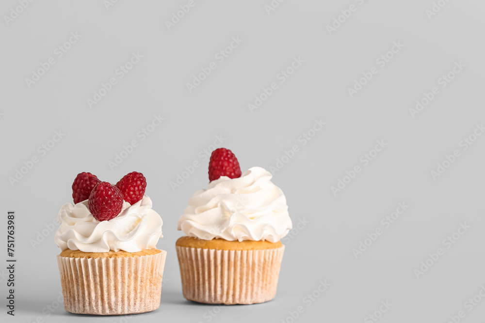 Tasty raspberry cupcakes on grey background