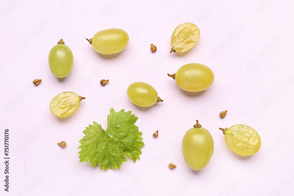 Fresh green grapes with leaf and seeds on lilac background