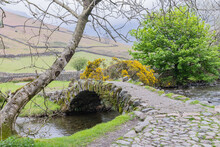 Stone Arch Bridge Across A Small Stream In Lake District National Park.