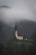 View of the old church in the fog in the town of Tristach in Austria