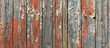 A close-up view of a weathered wooden fence with peeling paint, revealing a distressed and aged appearance.