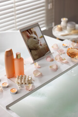 Canvas Print - Wooden tray with tablet, wine, toiletries and flower petals on bathtub in bathroom