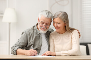 Canvas Print - Senior couple signing Last Will and Testament indoors