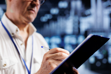 Poster - Skillful system administrator in crypto mining farm with specialized equipment using Blockchain technology. Fintech manager holding clipboard, inspecting asic rackmounts solving hashing operations