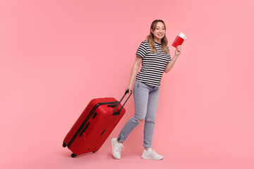 Sticker - Happy young woman with passport, ticket and suitcase on pink background