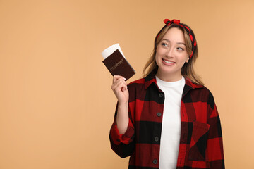 Poster - Happy young woman with passport and ticket on beige background, space for text