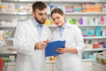 Poster - Professional pharmacists working together in modern drugstore