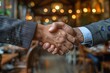 © Pinklife - Two businessmen in suits shaking hands while standing in a restaurant with a blurred background