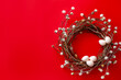 Easter wreath made from twigs decorated with white eggs on red background