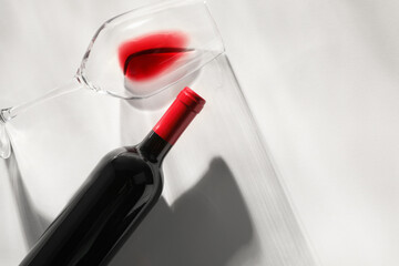 Sticker - Bottle of expensive red wine and wineglass on light background, top view. Space for text