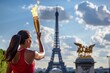 Athlete holding the lit Olympic torch with the Paris Eiffel Tower in the background during the Olympic Games
