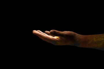 Sticker - Close up hand covered with holi powder isolated over black background. Holi festival concept.