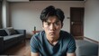 Angry frustrated korean young male man staring at the camera on a living room home background from Generative AI