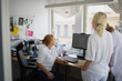 © Johnér - Gynecologist discussing with female colleagues over computer while working in clinic